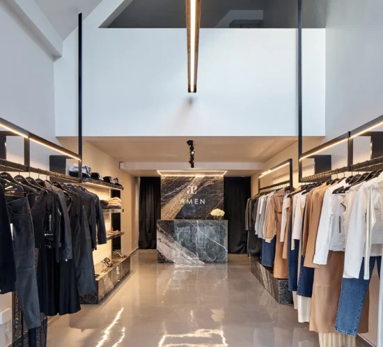 Espacio comercial de estética monocromática con mármol, detalles en acero y líneas limpias, diseñado para destacar prendas de cuero dentro de una atmósfera sofisticada y contemporánea.