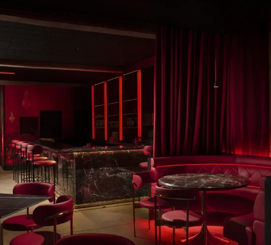 Espacio interior de Carloto inspirado en la Divina Comedia, con una atmósfera teatral construida mediante iluminación dramática, materiales envolventes y una narrativa espacial que guía el recorrido entre distintos niveles temáticos.